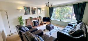 a living room with two leather couches and a fireplace at Chelmsford Comfort Retreat Spacious 4 Bedroom Sleeps 7 Free Parking in Widford