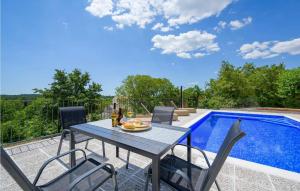 a patio with a table and chairs next to a swimming pool at Madonna Delle Nevi in Oprtalj