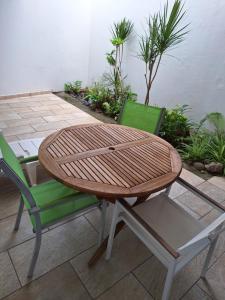 a wooden table and two chairs sitting next to a patio at Une petite halte à Terre-de-Haut in Terre-de-Haut