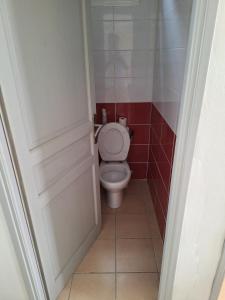 a bathroom with a toilet and red tiles at Une petite halte à Terre-de-Haut in Terre-de-Haut
