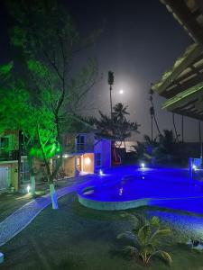 a swimming pool in a yard at night at Duplex Arembepe, beira mar, piscina i wifi in Camaçari