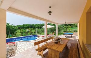 a living room with a table and a pool at Holiday Home Kranjci Kranjci in Raša
