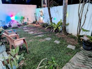 a yard with a chair and some plants and a wall at Costels Mirissa in Mirissa