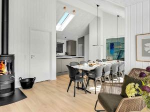 a dining room with a table and a fireplace at 5 star holiday home in Dronningmølle in Dronningmølle