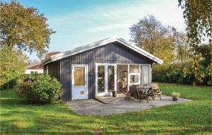 un pequeño cobertizo con una mesa y sillas en un patio en Three-Bedroom Holiday Home In Esbjerg V, en Esbjerg