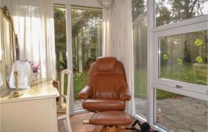una silla de cuero marrón sentada frente a una ventana en Three-Bedroom Holiday Home In Esbjerg V, en Esbjerg 10 fotos más