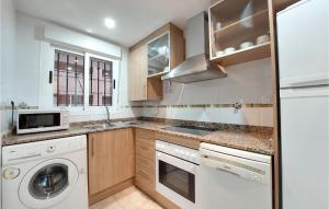 a kitchen with a washer and dryer and a microwave at Cozy Apartment In Oropesa Del Mar in Oropesa del Mar