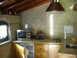 een keuken met een magnetron en een wastafel bij Casa Do Grilo Soajo in Soajo