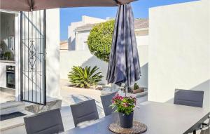 - une terrasse avec une table, un parasol et des fleurs dans l'établissement Amazing Home In El Chaparral With Wifi, à La Mata