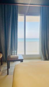 a bedroom with a bed and a window with the ocean at Resort Sur Beach Holiday in Sur +62 photos