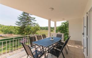 a patio with a table and chairs on a balcony at Three-Bedroom Holiday Home In Vinjani Gornji in Aračići