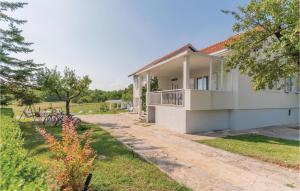a white house with a balcony and a yard at Three-Bedroom Holiday Home In Vinjani Gornji in Aračići