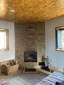 a living room with a brick fireplace and a bed at Casa do Avô Zé in Covas do Monte