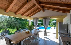 een buitenkeuken en eetkamer met een houten tafel en stoelen bij Casa Ida in Grožnjan