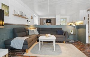 a living room with a couch and a table at Holiday Home Sandtoftevej Blåvand Ix in Blåvand +18 photos