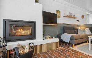 a living room with a fireplace and a couch at Holiday Home Sandtoftevej Blåvand Ix in Blåvand