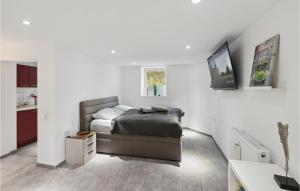 a bedroom with a bed and a white wall at 1 Bedroom Lovely Apartment In Nieheim in Nieheim