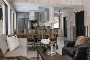 a kitchen and living room with a table and chairs at Nybyggd villa i Storhogna in Storhågna
