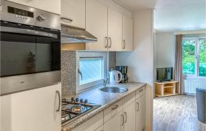a kitchen with a sink and a stove top oven at 2 Bedroom Gorgeous Home In Heinkenszand in Heinkensand