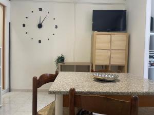a dining room with a table and a clock on the wall at Casa da Cinzia in Montoro Inferiore
