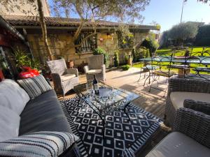 Un patio con sofás y una mesa y sillas. en Le Jardin Villemaurine, en Saint-Émilion