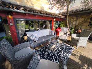 un patio con sofá y sillas en una terraza en Le Jardin Villemaurine, en Saint-Émilion