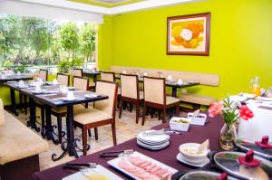 a dining room with tables and chairs and green walls at Alwa Hotel Boutique Premium in Arequipa