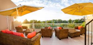a patio with chairs and tables and umbrellas at Alwa Hotel Boutique Premium in Arequipa