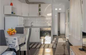 a kitchen with white cabinets and a table with oranges on it at Awesome Apartment In Crikvenica in Crikvenica