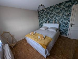 a bedroom with a bed with two towels on it at Maison Chez Papy Chapeau 4 étoiles in Leuvrigny