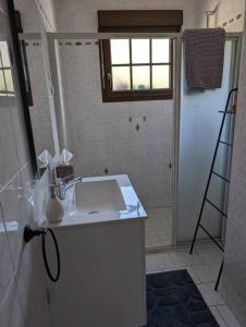 a bathroom with a white sink and a shower at Maison Chez Papy Chapeau 4 étoiles in Leuvrigny