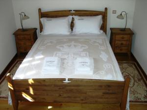 een slaapkamer met een groot bed met 2 nachtkastjes bij Casa Do Grilo Soajo in Soajo