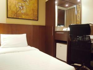 ein Schlafzimmer mit einem Bett, einem Waschbecken und einem Spiegel in der Unterkunft Roomz Hotel in Seria