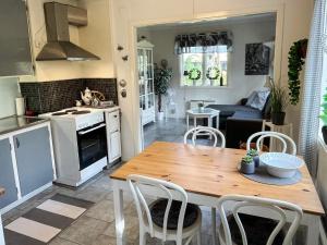 una cucina e un soggiorno con tavolo e sedie in legno di 4 person holiday home in FÄRJESTADEN a Färjestaden