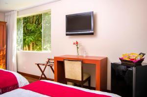 a bedroom with a desk and a tv on the wall at Alwa Hotel Boutique Standard in Arequipa