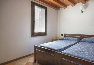 Un dormitorio con dos camas y una ventana en Stella House, en Ponte di Legno