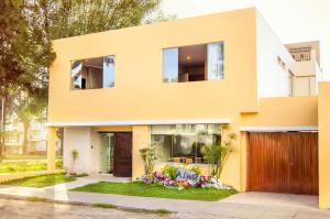 a yellow house with flowers in the front yard at Alwa Hotel Boutique Standard in Arequipa