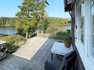 a porch with a table and a view of a lake at 4 star holiday home in LJUSFALLSHAMMAR in Kolvetorp