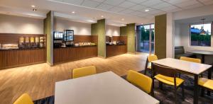 a restaurant with tables and chairs and a bar at Fairfield Inn & Suites by Marriott Moncton in Moncton
