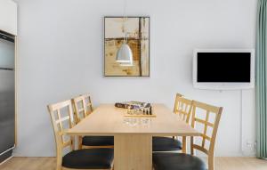 a dining room table with chairs and a tv at Gudhjem Søpark Lejl 18 in Gudhjem