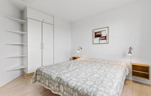 a white bedroom with a bed and white cabinets at Gudhjem Søpark Lejl 18 in Gudhjem +16 photos