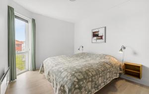 a white bedroom with a bed and a large window at Gudhjem Søpark Lejl 18 in Gudhjem