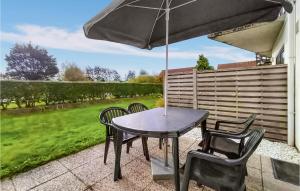 a table and chairs with an umbrella on a patio at Beautiful Apartment In Bredene in Bredene +9 photos