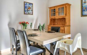 a dining room table and chairs with a wooden table and a cabinet at Beautiful Apartment In Bredene in Bredene