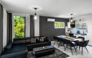 ein Wohnzimmer mit einer schwarzen Couch und einem Tisch in der Unterkunft Lovely Home In Novo Zvecevo With Sauna in Novo Zvecevo