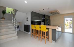 a kitchen with yellow bar stools and a staircase at Gorgeous Home In Donji Vinjani in Topići