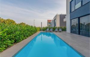a swimming pool with chairs next to a building at Amazing Home In Pasman in Živica