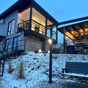 a house with a porch and a swing in the snow at Provance House in Slavske