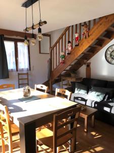 a living room with a dining room table and a staircase at chalet mitoyen en duplex in La Joue du Loup