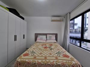 a bedroom with a bed with a floral bedspread at Casa a 100 metros da praia de Balneário Camboriú in Balneário Camboriú